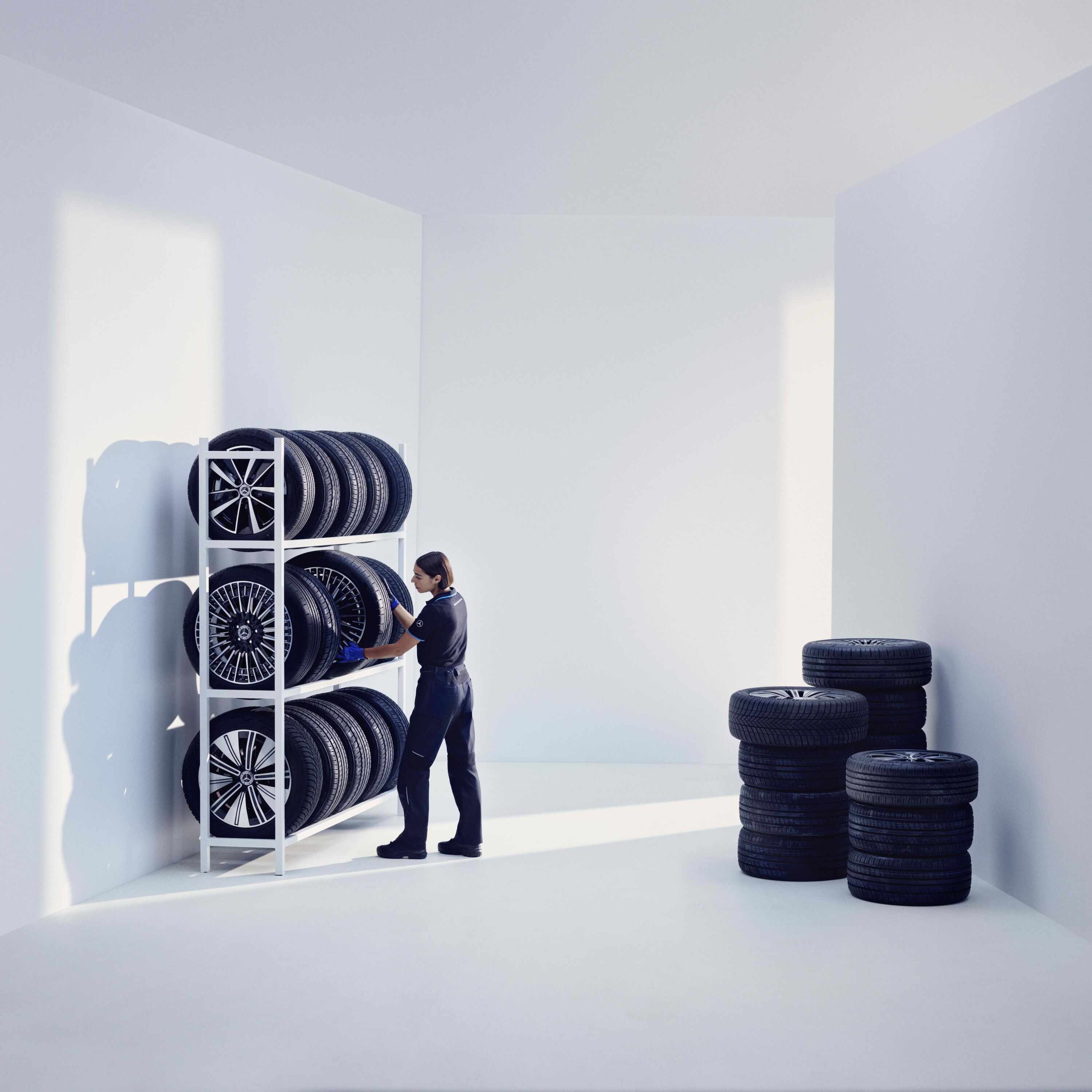 Một kỹ thuật viên của Mercedes-Benz lưu trữ lốp xe chính hãng Mercedes-Benz trên kệ.