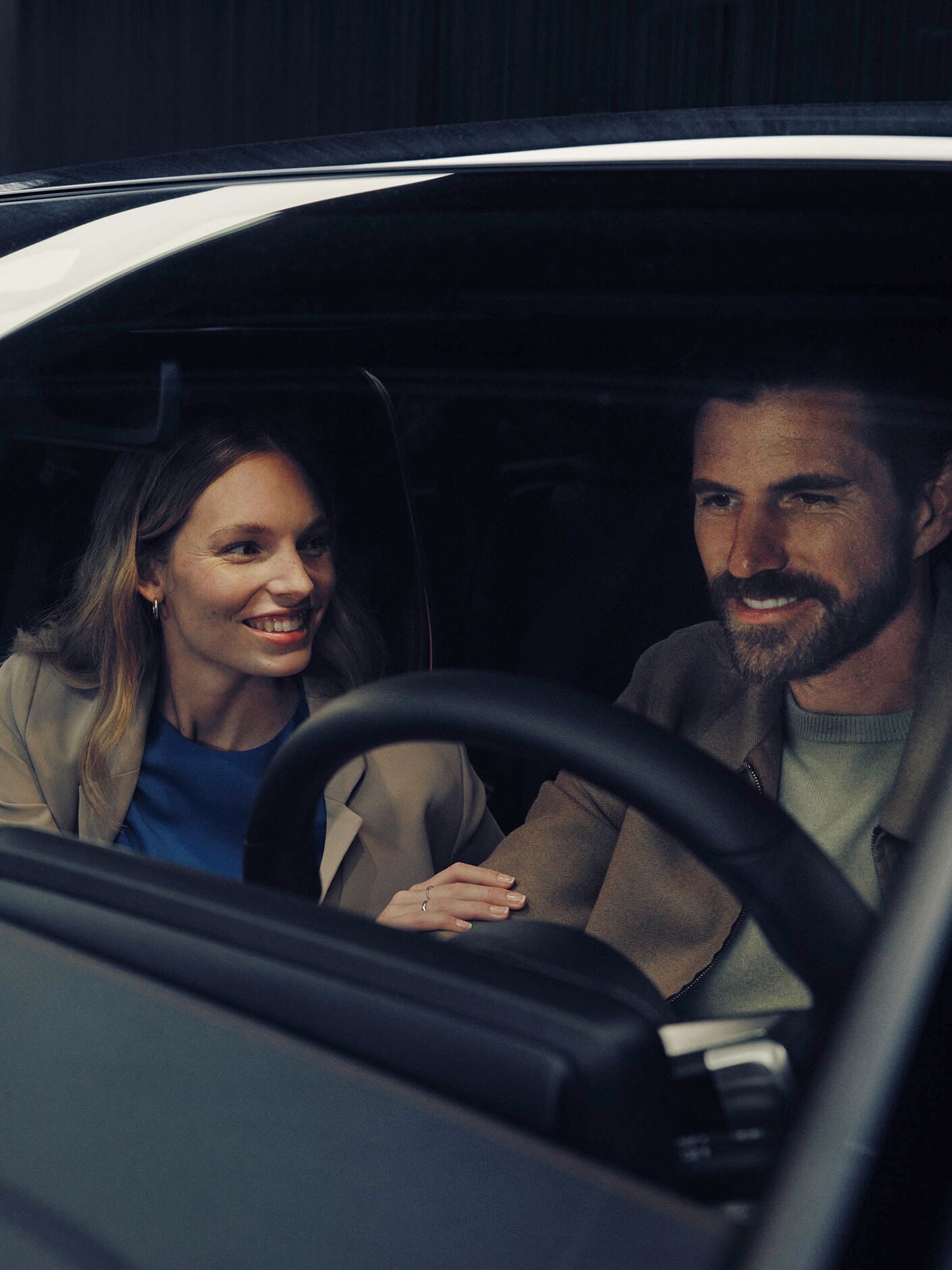 A man and woman sitting in a Mercedes-Benz EQS