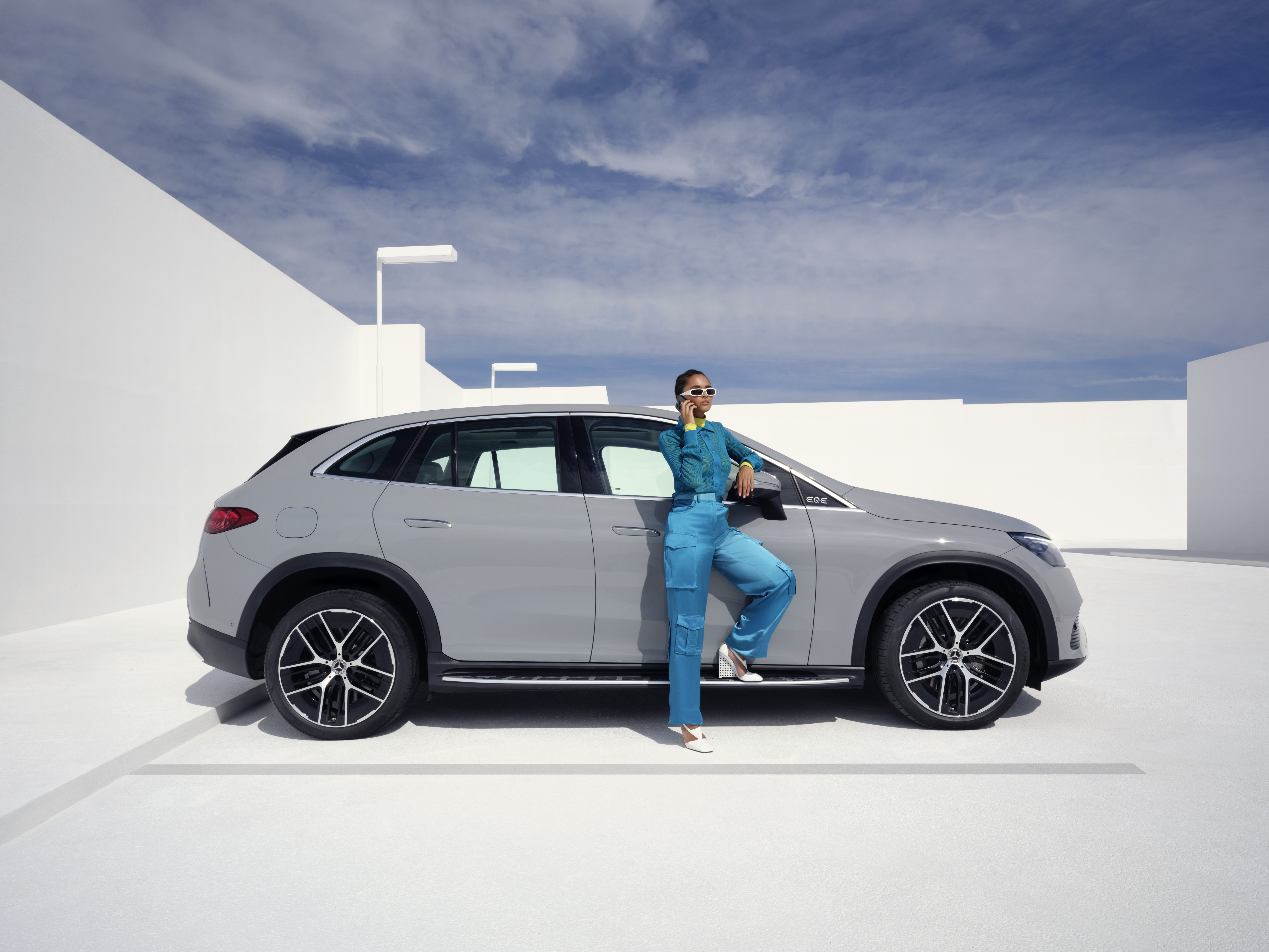 Hỗ trợ thiệt hại và sự cố | Mercedes-Benz Người phụ nữ cầm điện thoại di động đứng trước xe Mercedes-Benz của mình và đang gọi điện.
