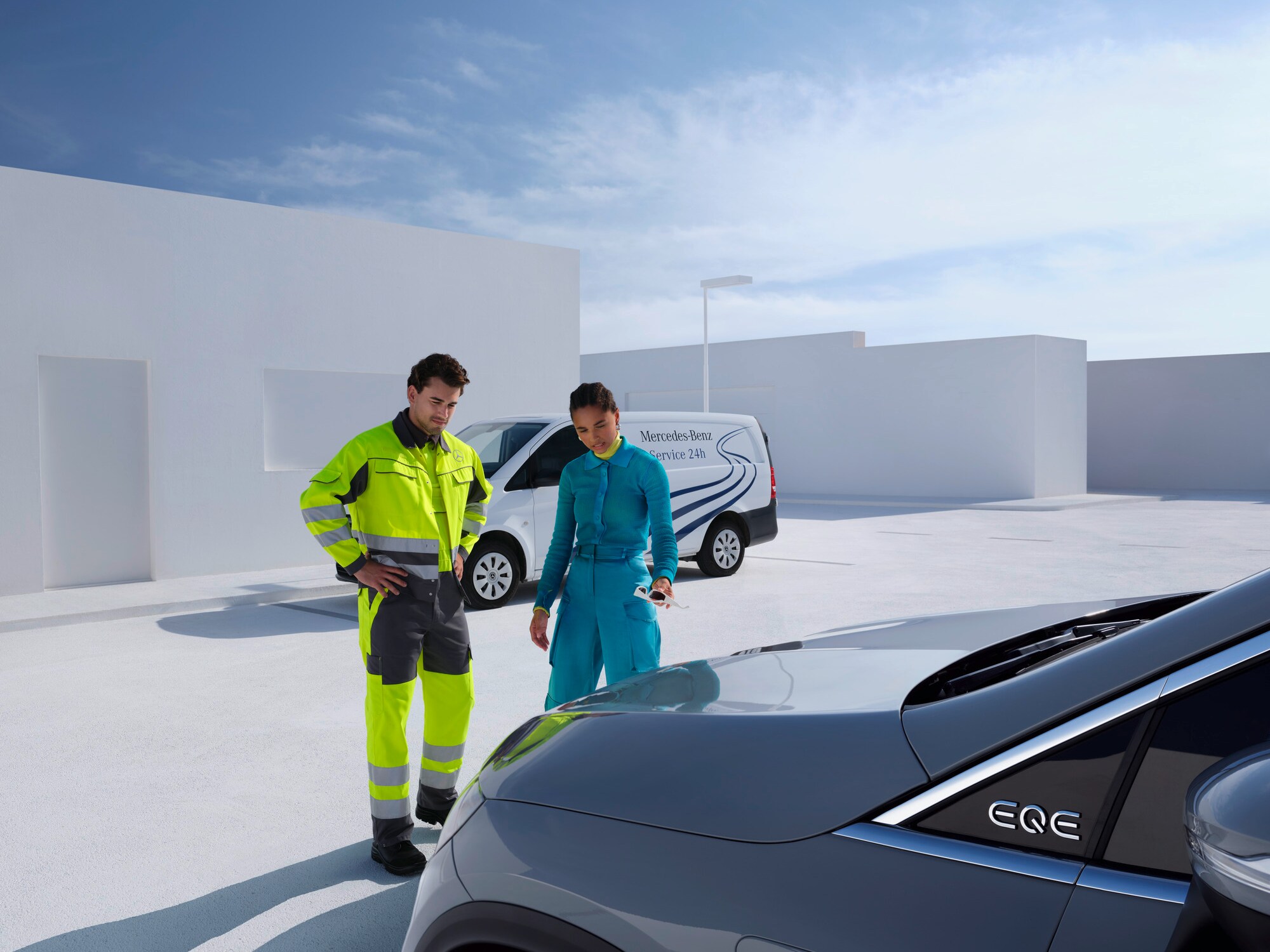 Người đàn ông từ Đội ngũ hỗ trợ Mercedes-Benz Service24 đứng cùng người phụ nữ trước xe Mercedes-Benz của cô ấy