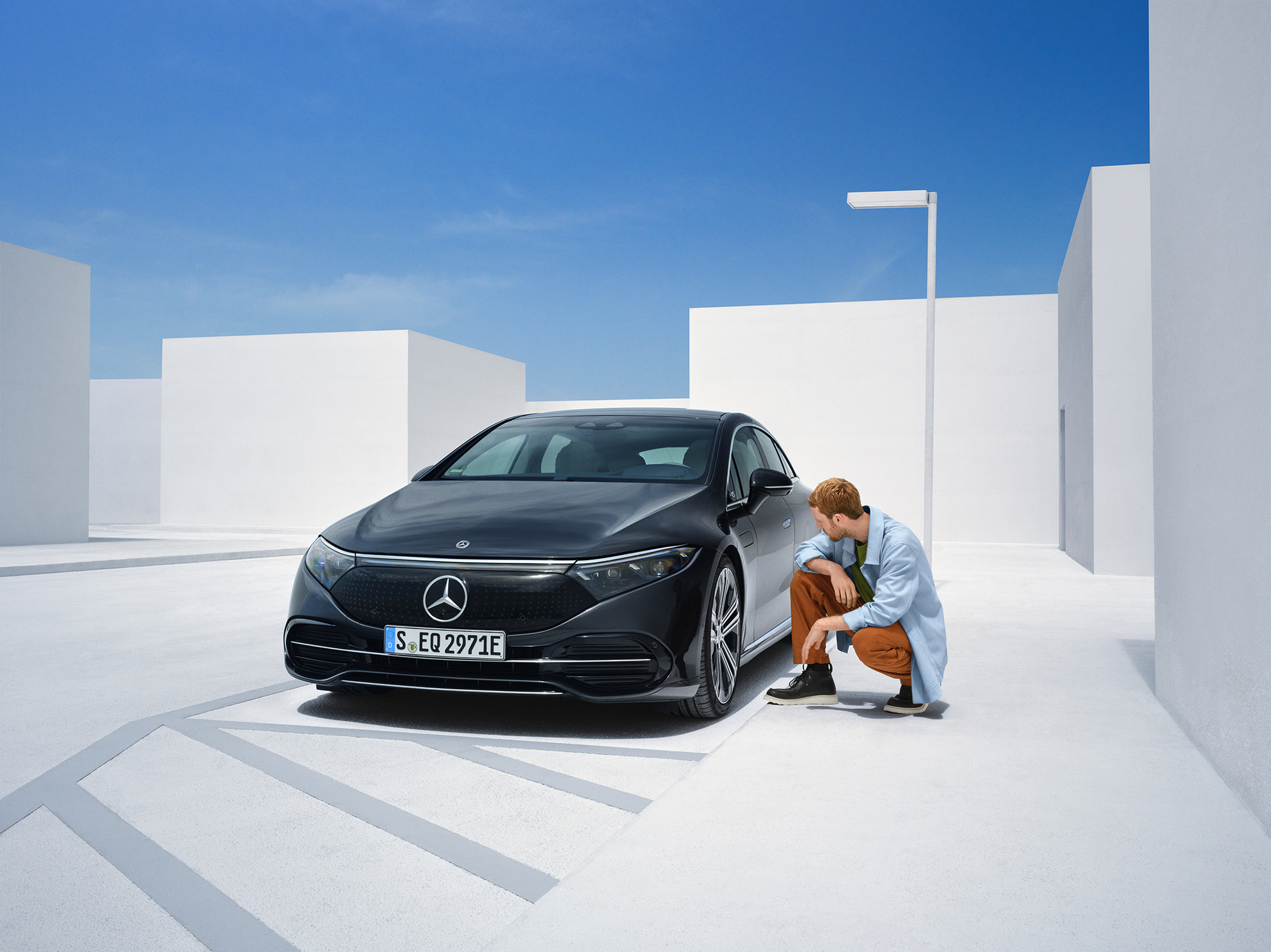 Thiệt hại do tai nạn | Mercedes-Benz Một người đang quỳ bên hông xe Mercedes-Benz của mình để kiểm tra xe.