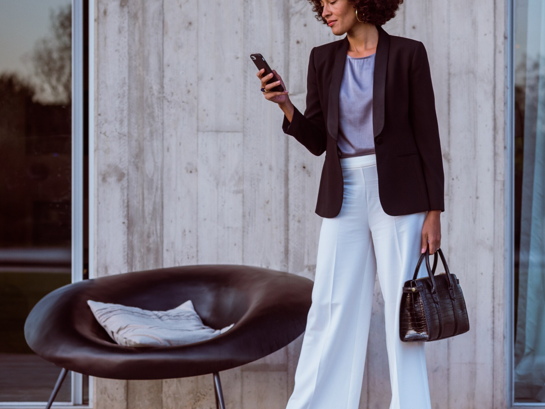 A woman connects to her Mercedes-Benz via smartphone, the Mercedes App and her Mercedes me ID.
