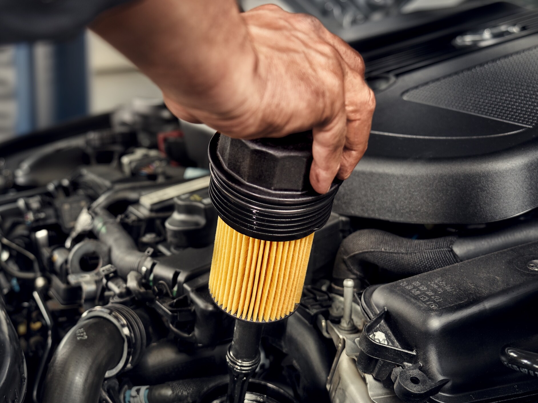 Một kỹ thuật viên đang lắp đặt bộ lọc dầu cho xe Mercedes-Benz.