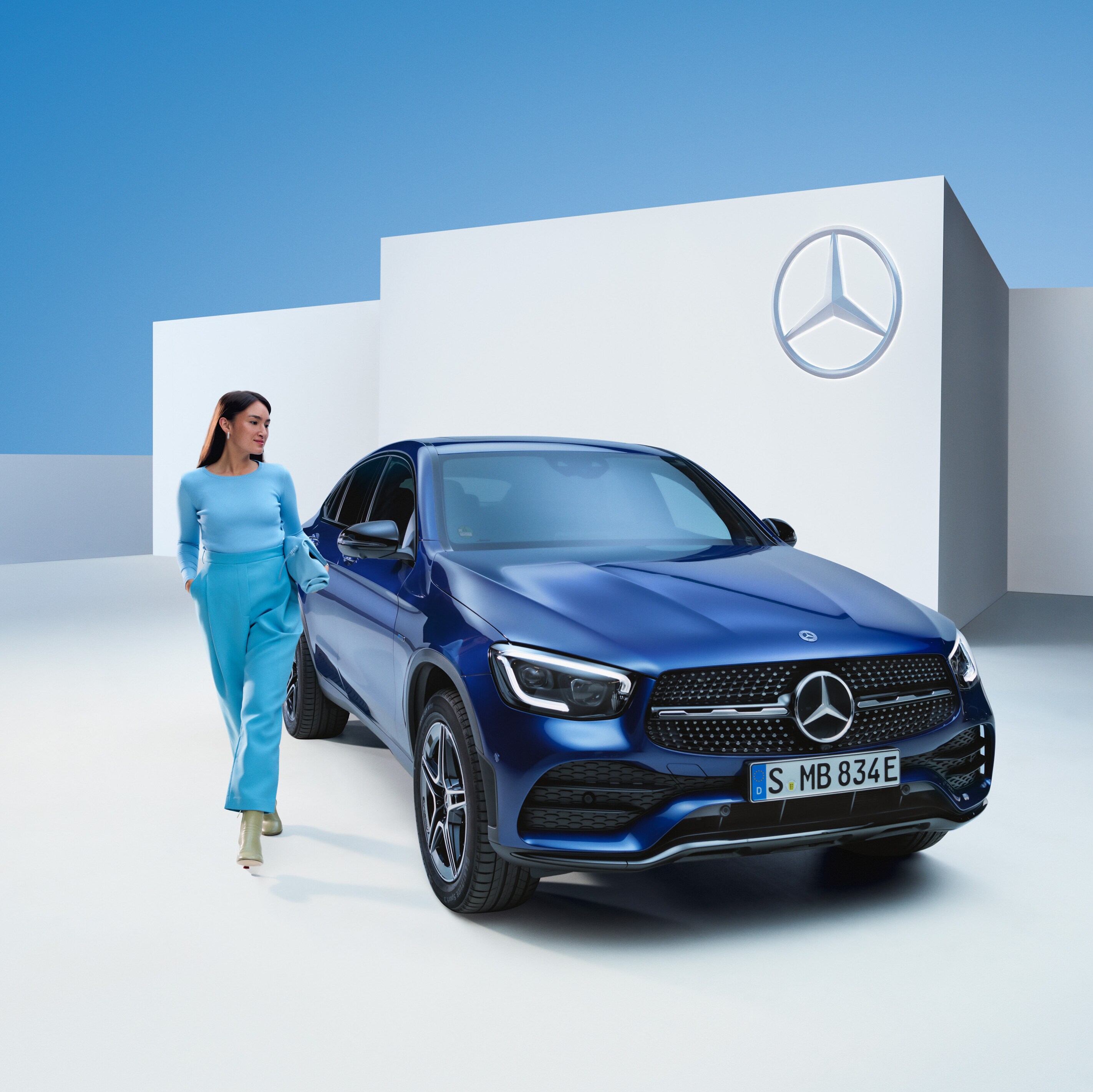 Một người phụ nữ thư giãn bên cạnh chiếc Mercedes của mình.