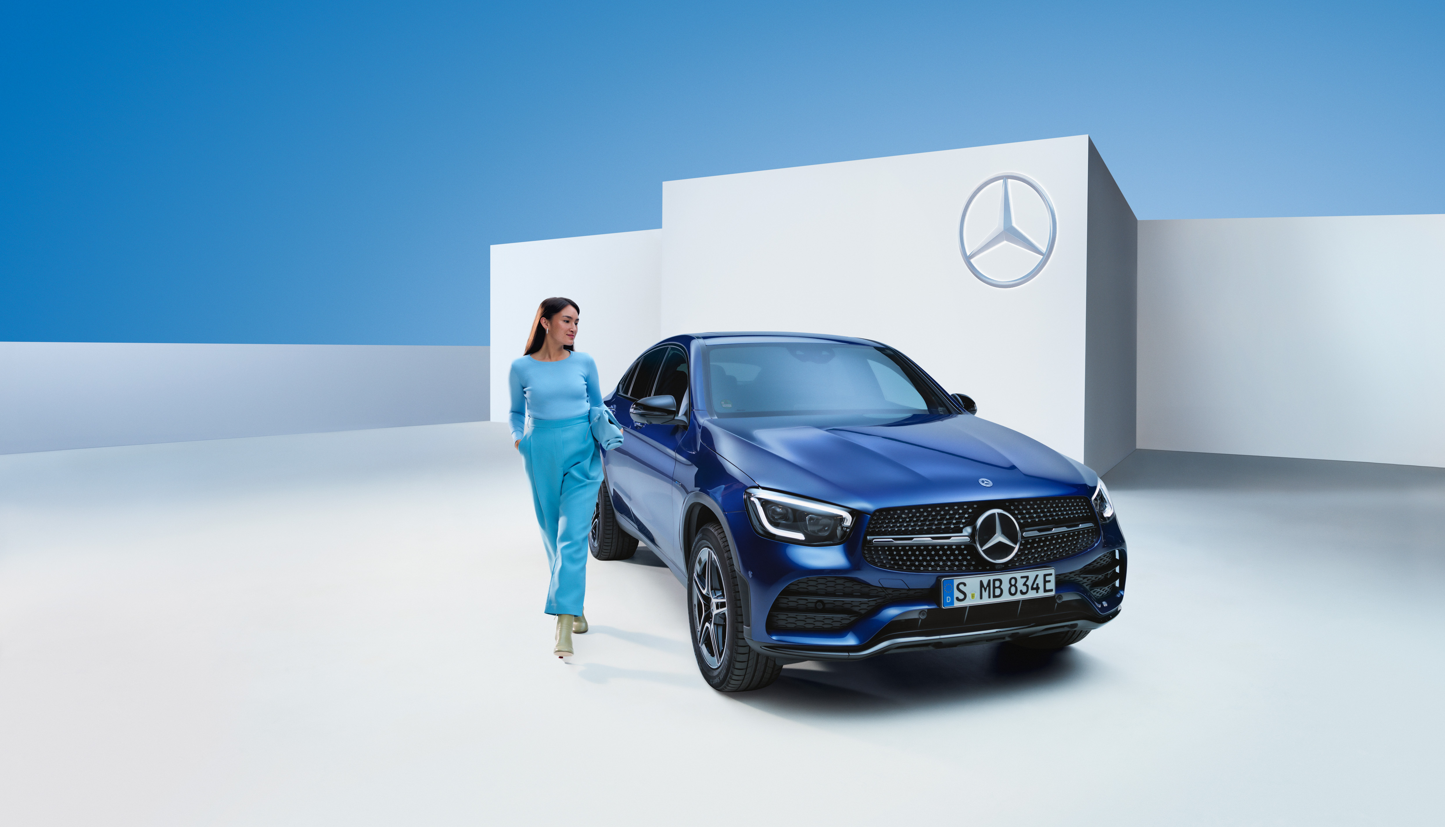 Mercedes-Benz Warranty | Mercedes-Benz A walking person next to a Mercedes-Benz vehicle.