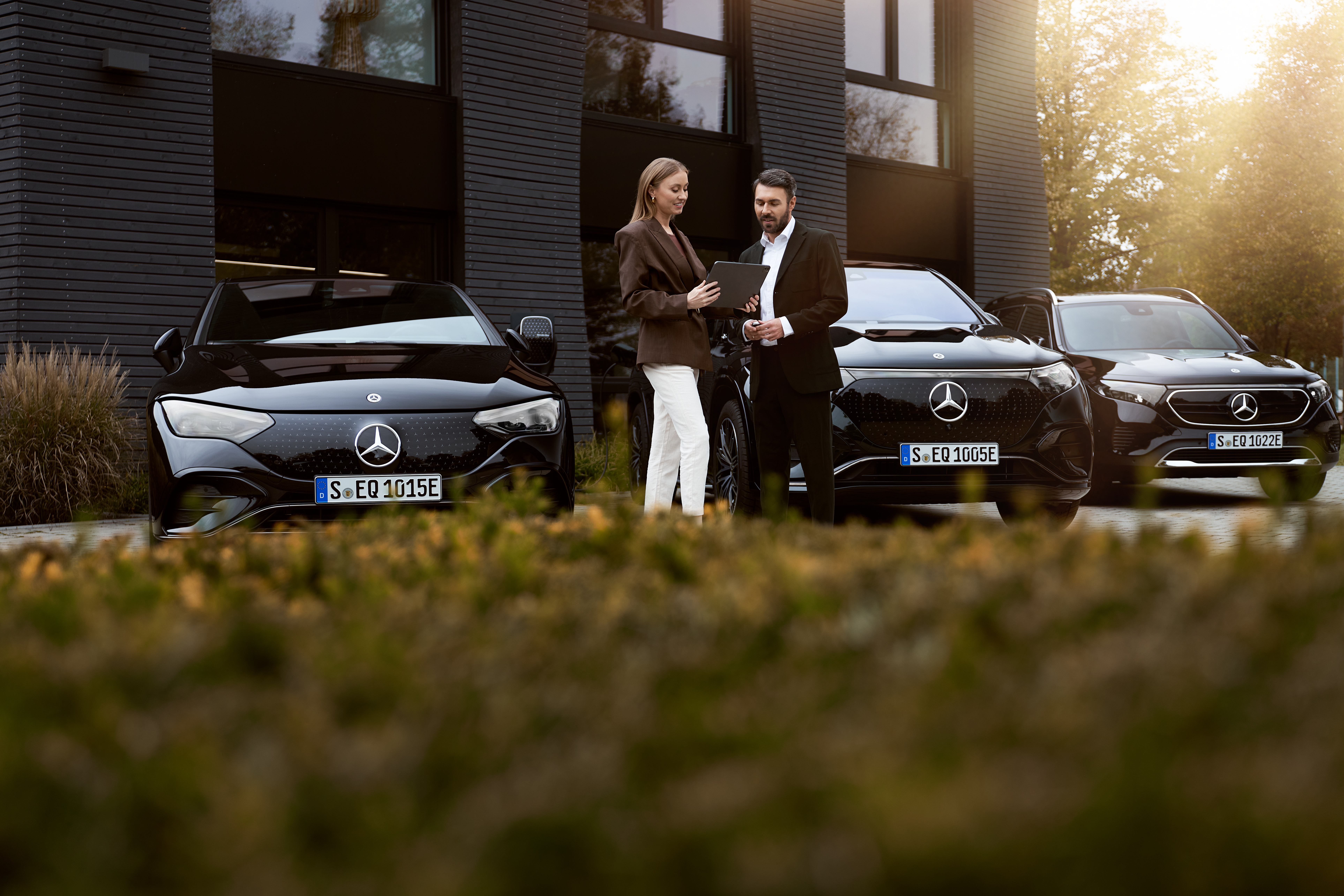 Chương trình ưu đãi dành cho Khối doanh nghiệp và Ngành nghề trọng điểm Hình ảnh hai người đang trao đổi giấy tờ và xe điện Mercedes-Benz