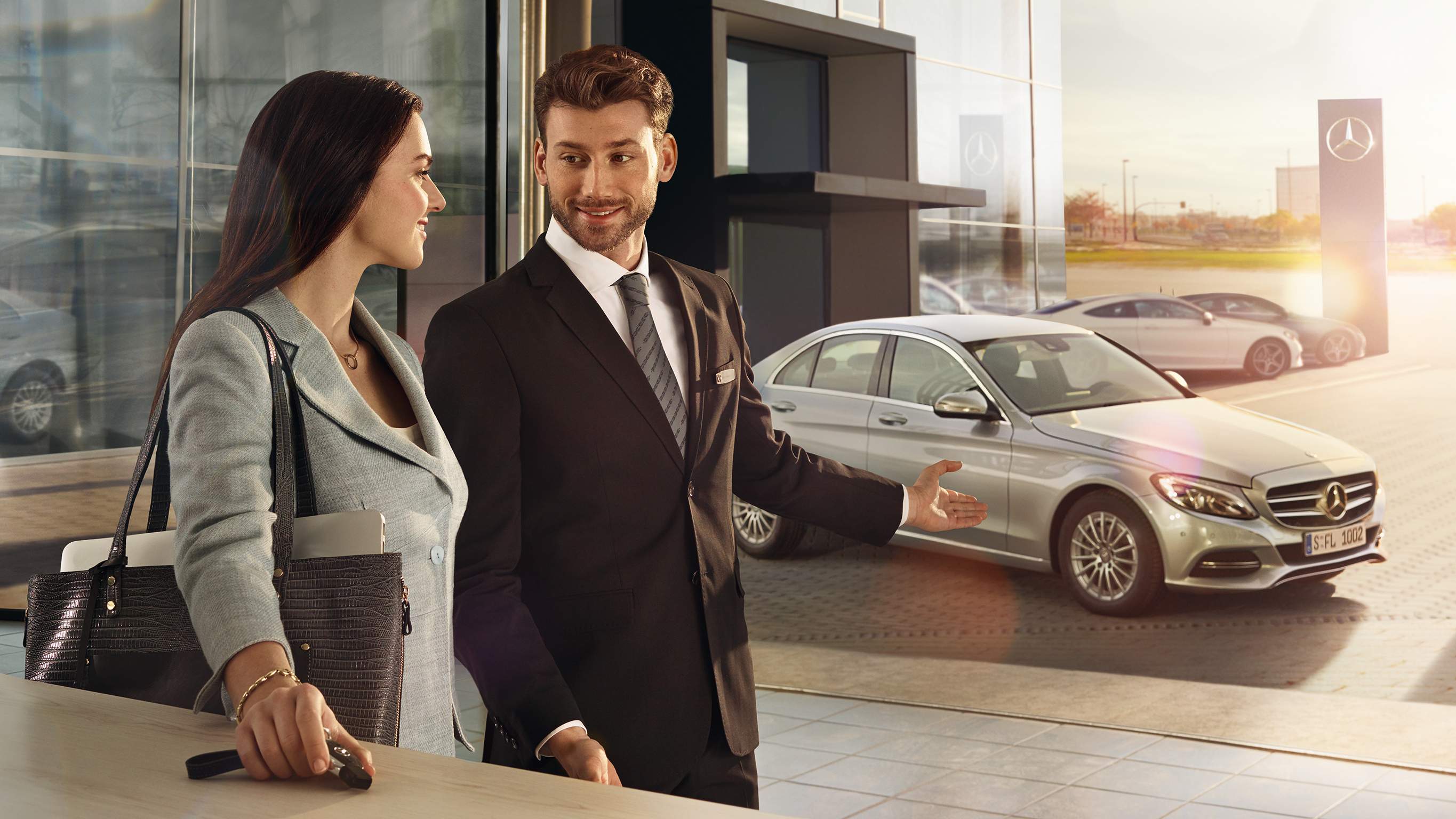Exclusive privileges for corporates and key professional groups A Mercedes-Benz consultant discussing vehicle details with a customer – Exclusive privileges for corporates and key professional groups