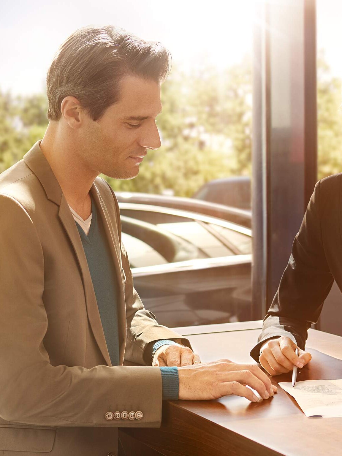 Staff assisting a customer inside a Mercedes-Benz showroom – Exclusive privileges for corporates and key professional groups