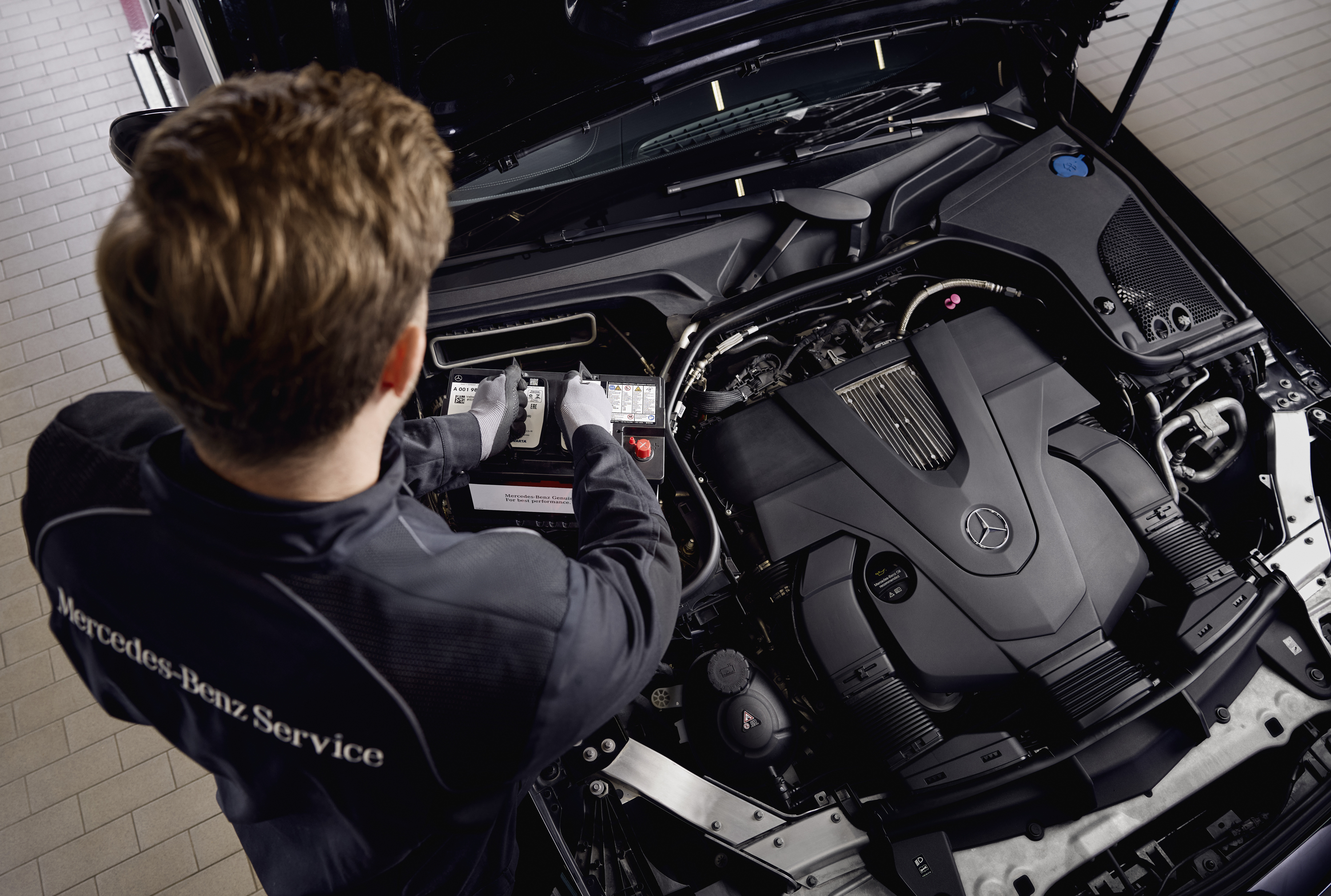 Ắc quy khởi động chính hãng Mercedes-Benz Dịch vụ bảo dưỡng động cơ tại xưởng, thể hiện việc thay thế các linh kiện bằng phụ tùng chính hãng Mercedes‑Benz.